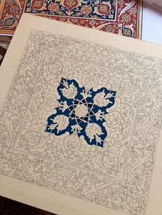 an intricately designed book with blue and red designs on the cover is sitting on a table