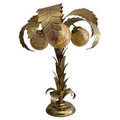 a golden vase with three balls and leaves