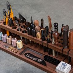 an assortment of sewing tools and thread spools on a wooden stand with scissors