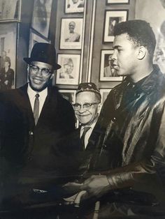 three men standing next to each other in front of pictures