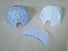 two hats are laying next to each other on a tablecloth covered surface, one is white and the other is blue