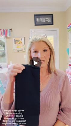 a woman holding up a black piece of cloth