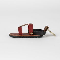 Step into style with the Chappal Mini Sandal Leather Keychain! This fun and quirky accessory is made from scrap buffalo leather, making it not only fashionable and fun, but also environmentally friendly. The assorted colors make it perfect for the fashion-forward, eco-conscious individual. This sandal keychain is a playful addition to any keyring. (Because who doesn't love a little footwear on their keys?)