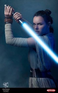 a woman holding a light saber in her right hand