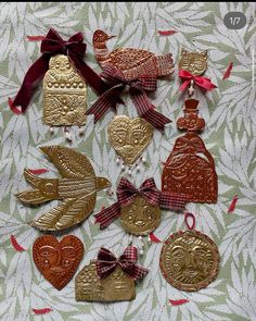 several ornaments are arranged on a table with red ribbons and bows around the edges, including two heart shaped ornaments