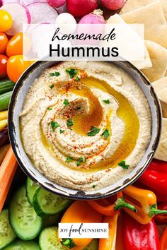 hummus in a bowl surrounded by vegetables and crackers with the title overlay reads homemade hummus