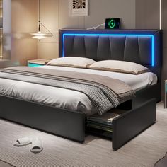 a bedroom with a bed, night stand and headboard illuminated by blue lights in the corner