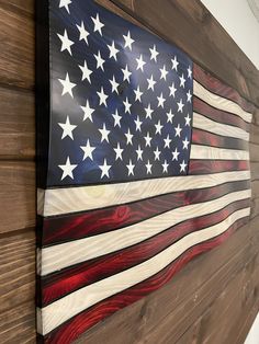 an american flag made out of wood is hanging on the side of a wall in a room