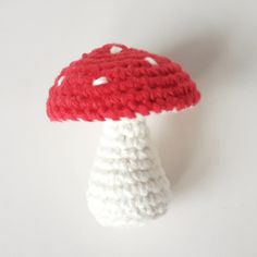 a crocheted red and white mushroom sitting on top of a table