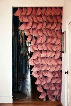 a room with pink decorations hanging on the wall and wood floors in front of it