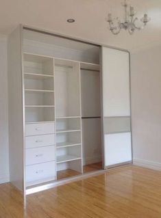 an empty room with white closets and wooden floors