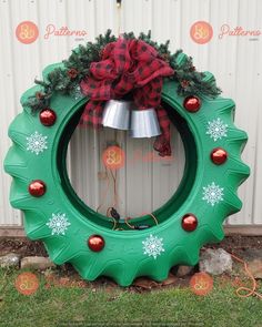 a green christmas wreath sitting on top of a grass covered ground