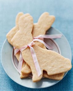 some cookies are sitting on a plate with pink ribbon around the edges and one is shaped like an angel