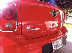 the back end of a red car parked in a driveway