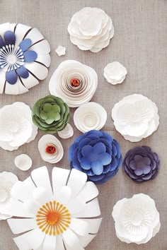 paper flowers are arranged on the table for decoration or wall hangings in various shapes and sizes