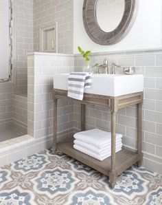 a white sink sitting under a mirror in a bathroom