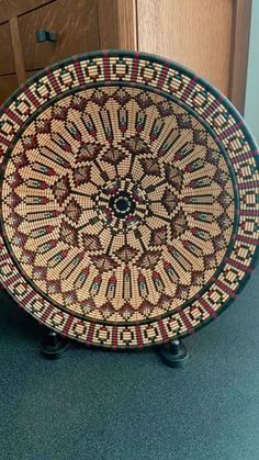 a decorative plate sitting on top of a wooden table next to a dresser with drawers