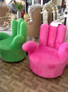 two colorful chairs sitting next to each other on a wooden floor in front of mirrors