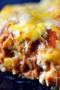 a close up view of some food with cheese and sauce on it's surface