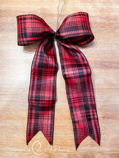 a red and black plaid bow on a wooden surface