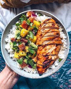 a bowl filled with chicken, rice and vegetables