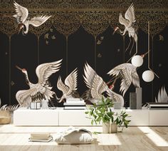 three birds flying in the air over a room with black wallpaper and white furniture