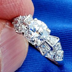 a close up of a person's hand holding a diamond ring