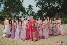 a group of women standing next to each other on a beach