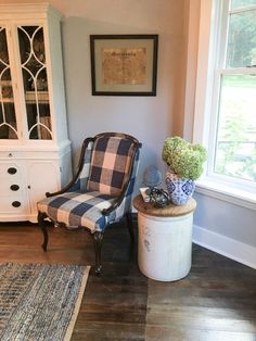 a living room with a chair, china cabinet and rug on the hardwood flooring