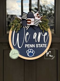 we are penn state door hanger with footballs and leaves on the front porch