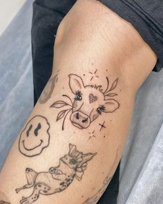 a person with a tattoo on their arm that has a cow and dog in it