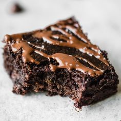 a piece of chocolate cake with frosting on it sitting on top of a table