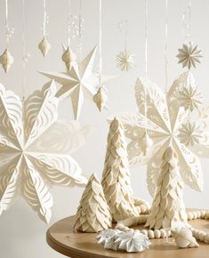 paper snowflakes and christmas trees on a table