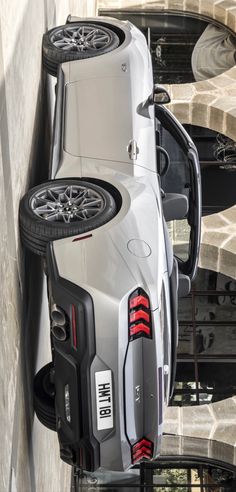 two cars parked next to each other on the side of a building with their doors open