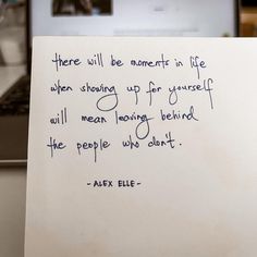 a piece of paper with a quote written on it next to a laptop computer and keyboard