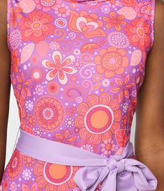 This groovy 1960's style jumpsuit from Smak Parlour is crafted in a lilac knit blend and boasts orange florals throughout. Outfitted with a cowl neckline, back zipper and purple self-tie sash to cinch your waist. Complete with side pockets.Available in sizes XS-4X while supplies last. Floral Tights, Spring Floral Prints, 1960s Outfits, Retro Rainbow, Floral Accessories, Spring Trends, 1960s Fashion, Inspired Dress, Purple Floral