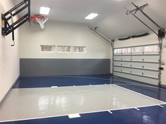 an indoor basketball court in the middle of a garage with blue and white flooring