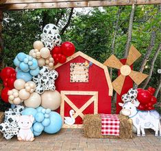 a barn with balloons and farm animals on the front yard for a baby shower or birthday party