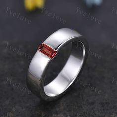 a silver ring with a red stone in the middle