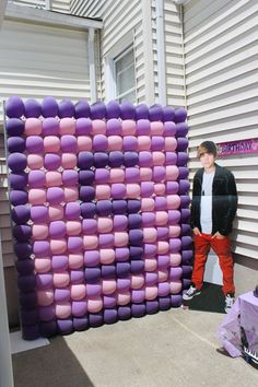 a man standing next to a giant purple and pink object