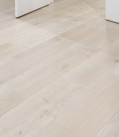 an empty room with white furniture and wood flooring