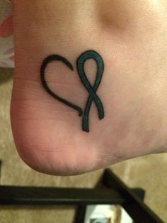 a small tattoo on the foot of a person with a blue ribbon in the shape of a heart