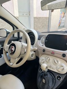 the interior of a car with steering wheel and dashboard