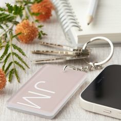 a cell phone sitting on top of a table next to a keychain and flowers