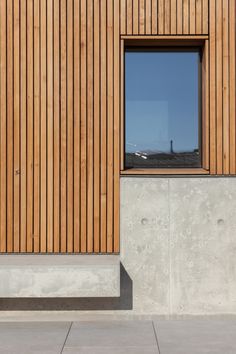 the side of a building with wooden slats on it's walls and windows