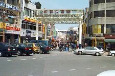 a city street filled with lots of traffic and people walking on the side of it