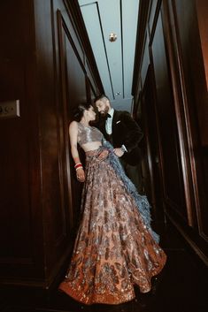 a man and woman in formal wear standing next to each other on a hallway way