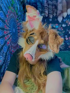 a woman with long hair and a mask on her face is sitting in front of an umbrella