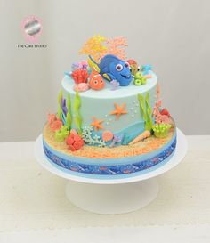 a blue and white cake with an ocean theme on the top is sitting on a table