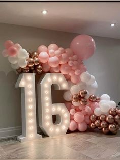 a large balloon arch with the number sixteen surrounded by balloons